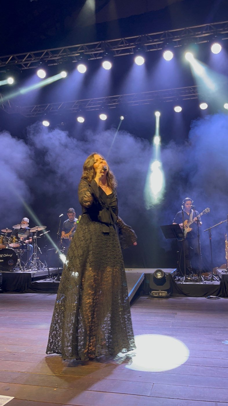 Isa Oliver cantando, com a banda ao fundo